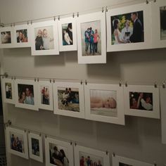 many pictures are hung on the wall with clothes pins