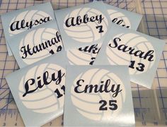 four stickers with the names and numbers of volleyball players are shown on a cutting board