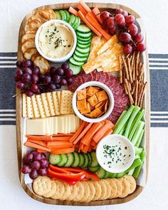 a platter filled with cheese, crackers and vegetables