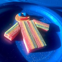 a blue plate topped with rainbow colored cake