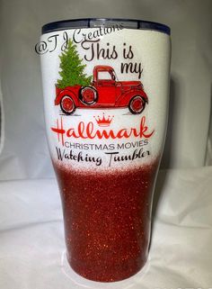 a red and white tumbler cup with a christmas tree on it's side