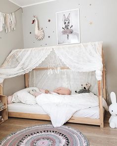 a child's room with a bed, rugs and pictures on the wall