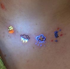 the back of a woman's stomach with four different colored clouds and stars on it