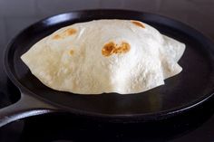 two tortillas sitting on top of a black skillet