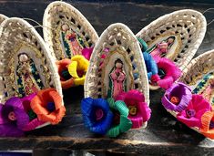 several woven baskets with colorful ribbons and flowers in them on a wooden surface, one has a doll hanging from the top