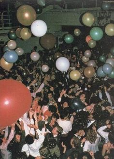 a large group of people at a party with balloons