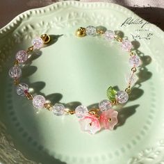 "Transport yourself to a whimsical, ethereal realm with the delicate beauty of our handcrafted fairycore-inspired bracelet. This piece is designed to capture the essence of a fairy garden, where every flower glistens with a hint of magic. Key Features:  Shiny Pink Glass Beads: The bracelet is adorned with lustrous pink glass beads that shimmer and shine, reminiscent of dew-kissed petals in the morning light. Floral Elegance: The centerpieces of this bracelet are charming glass flower beads, each intricately detailed to replicate the allure of a fairy's haven. These dainty flowers add a touch of whimsy to your style.🌸  Versatile Beauty: Whether you're dancing in a forest glade, attending a fairy-themed event, or simply wanting to infuse your everyday look with a touch of enchantment, this Delicate Flower Shaped Crystal Bracelet Gift, Delicate Flower Shaped Crystal Bracelet As Gift, Delicate Pink Bracelet With Flower Charm, Fairycore Flower Shaped Jewelry Gift, Fairycore Flower Jewelry For Gifts, Adjustable Fairycore Bracelets As Gifts, Whimsical Handmade Beaded Bracelets For Party, Delicate Pink Bracelets For Jewelry Making, Handmade Bracelets For Spring Weddings