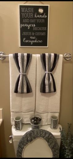 a bathroom with two black and white towels hanging on the wall next to a toilet