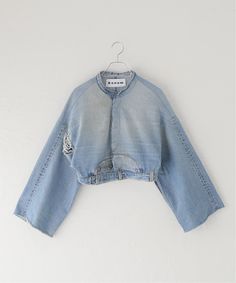 a blue jean jacket hanging on a white wall