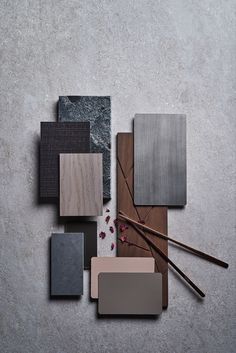 several different types of wood and tile on a gray surface with chopsticks next to them