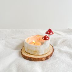 a candle that is sitting on top of a piece of wood in the shape of a mushroom