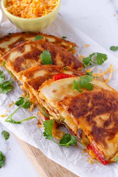 two quesadillas cut in half with cheese and cilantro on the side