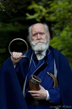 an old man with a long white beard holding a magnifying glass in his hand