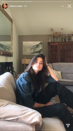 a woman sitting on top of a couch in a living room