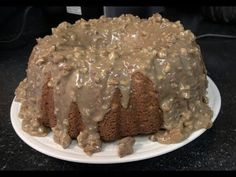 a bundt cake covered in frosting on a white plate with a black counter top