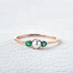 Freshwater Pearl Emerald Ring, 14K Solid Gold Ring, Engagement Ring, June birthstone, Three stone Ring, Anniversary Gift For Women's Jewelry Main Stone: Fresh Water Pearl Main Stone Color: White Main Stone Shape: Round Main Stone Size: 5mm Birthstone Month: June Second Stone: Emerald Stone Shape: Round Stone Color: Green Jewelry Type: Ring Metal: Silver Method: Cast Personalization: Possible Style: Chevron Ring Size: We make rings from US 3 to US 10. This elegant ring is perfect for any occasion Fine Jewelry Pearl Ring With Birthstone For Anniversary, 14k Gold Pearl Birthstone Ring Fine Jewelry, Fine Jewelry 14k Gold Birthstone Pearl Ring, 14k Gold Pearl Ring With Birthstone, Emerald Birthstone Cluster Ring, Emerald Three Stone Birthstone Ring As Gift, Fine Jewelry Pearl Ring With Birthstone, Three Stone Emerald Birthstone Ring As Gift, 14k Gold Multi-stone May Birthstone Ring