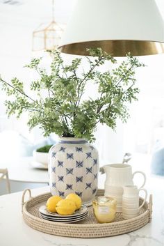 a white and blue vase sitting on top of a table with lemons in it