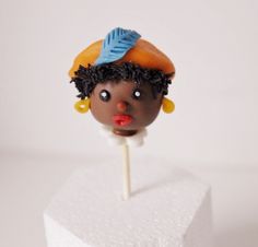 there is a cake topper that looks like a woman's head on a stick