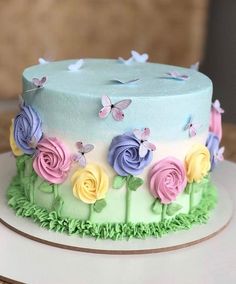 a multicolored cake decorated with flowers and butterflies