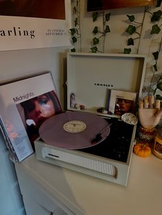 a record player sitting on top of a table next to a box with an album