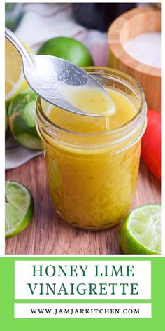 a spoon full of honey lime vinaigrete on top of a wooden cutting board