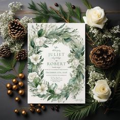 an elegant wedding suite with greenery, flowers and pine cones is displayed on a table