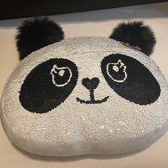 a panda bear head made out of sequins on a white counter top with black ears