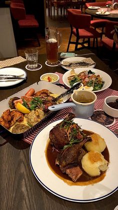 a table topped with lots of plates of food