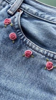 a pair of jeans with pink roses on them