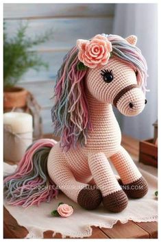 a crocheted stuffed horse sitting on top of a table