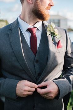 a man in a gray suit and red tie