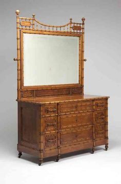 an old dresser with a mirror on top and bamboo decoration around it's edges