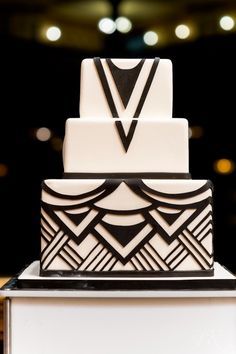 a white and black wedding cake with an art deco design