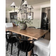 a dining room table with four chairs and a potted plant on the top of it