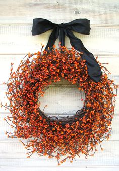 a close up of a wreath on a door with a blue bow hanging from it