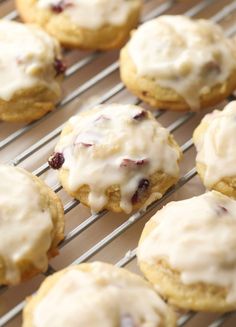 cookies with icing and cranberries are cooling on a rack in the oven