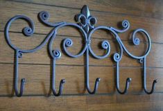 four wrought iron hooks hang on the wall next to a wood paneled wall with text overlay that says regular price $ 399 99 each