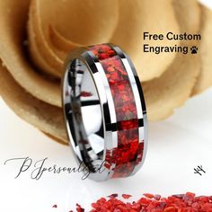 a wedding ring with red flowers inlayed to the center and black plated edges