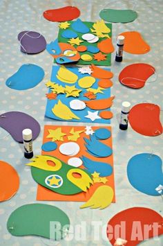 the table is covered with paper and crafting supplies for children to use on crafts