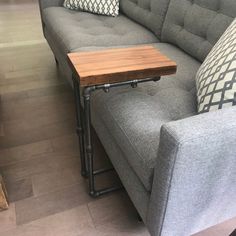 a gray couch with a wooden table on it