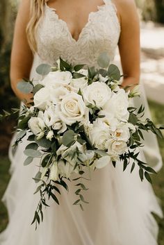 a bride holding a bouquet of white flowers