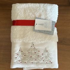 two white towels with christmas trees on them, one is red and the other is white