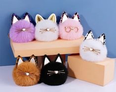 four different types of cat purses sitting on top of a shelf