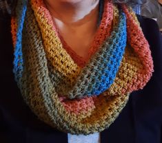 a woman wearing a multicolored crocheted scarf