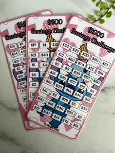 two pink playing cards with numbers and symbols on them, sitting next to each other