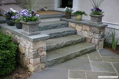 the steps are made from stone and have flower pots on them