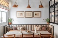 a dinning room table with four chairs and two pictures on the wall above it