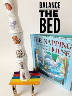 a stack of children's books next to a tall toothbrush holder with the words balance the bed on it