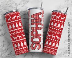 two red and white christmas tumblers sitting on top of a marble counter next to each other