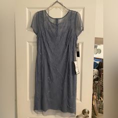 a gray dress hanging on a door